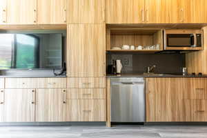 Kitchen with stainless steel appliances, modern cabinets, and light brown cabinets