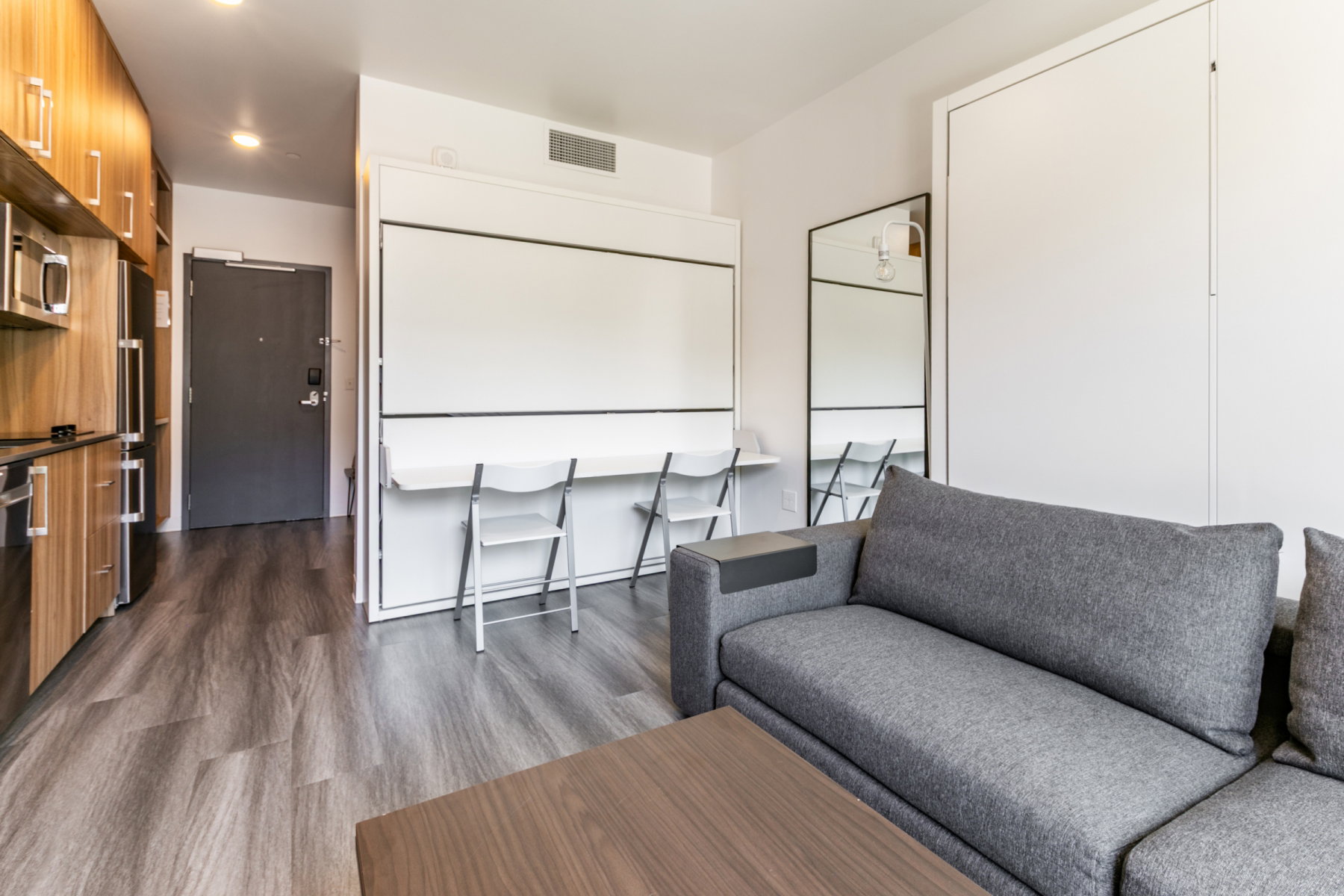 Living area featuring dark wood-style flooring and recessed lighting