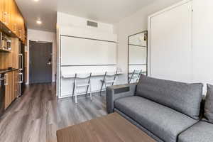 Living area featuring dark wood-style flooring and recessed lighting