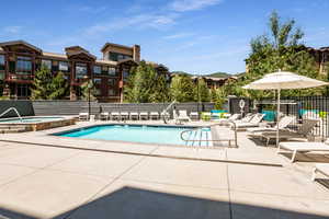 Community pool with a patio area and a hot tub