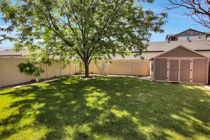 Fenced backyard with a storage shed