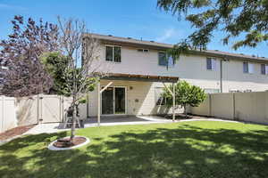 Back of house with a gate, a fenced backyard, and a covered patio