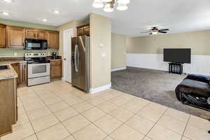 Kitchen with stainless steel fridge with ice dispenser, electric range, black microwave, open floor plan, and light colored carpet