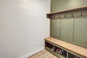Mudroom with light wood-style flooring and baseboards