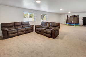 Carpeted living room with recessed lighting and baseboards