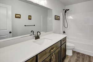 Bathroom featuring wood finished floors, vanity, and shower / bathtub combination