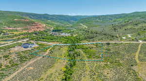 Aerial overview of property's location featuring a mountainous background and property parcel outlined