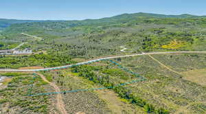 Aerial overview of property's location with a mountainous background and property parcel outlined