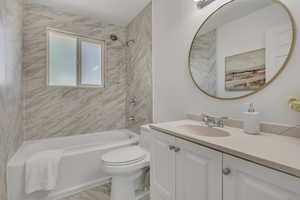 Full bath with vanity, bathing tub / shower combination, and marble finish flooring