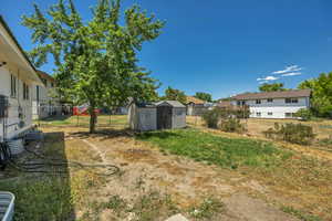 Fenced backyard with a storage unit and a residential view