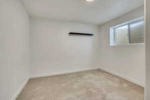 Carpeted empty room featuring baseboards