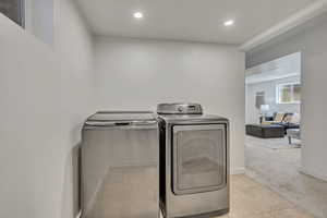 Washroom with independent washer and dryer, light colored carpet, recessed lighting, and light tile patterned floors