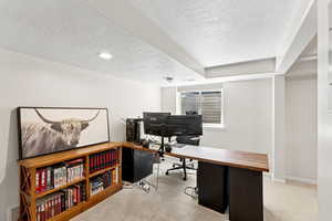Home office with a textured ceiling and carpet floors