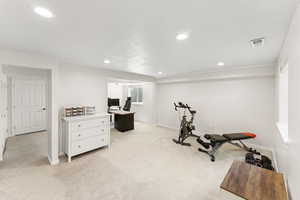Workout area featuring light colored carpet and recessed lighting