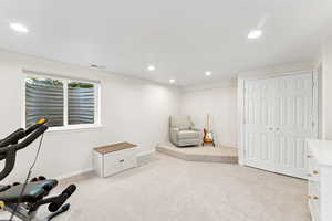 Workout room with light carpet and recessed lighting