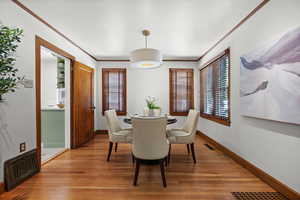 Dining room featuring light wood-style flooring and ornamental molding