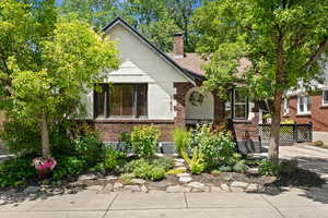 View of front of home with brick siding and a chimney