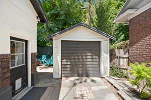 Detached garage with driveway and a storage shed