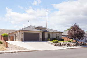 View of front of property with stone siding, a garage, concrete driveway, stucco siding, and a tiled roof