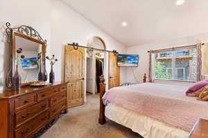 Bedroom featuring lofted ceiling, light colored carpet, a spacious closet, recessed lighting, and a closet