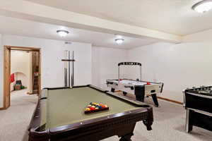 Playroom with carpet floors, a textured ceiling, and pool table