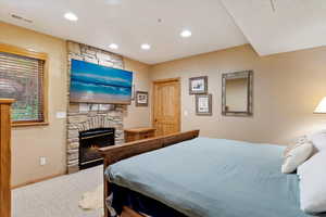 Bedroom with carpet, a fireplace, and recessed lighting