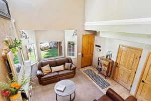 Living room with a towering ceiling and tile patterned flooring