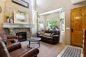 Living area with a stone fireplace and baseboards