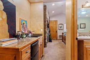 Bar area with light carpet, black dishwasher, recessed lighting, and vaulted ceiling