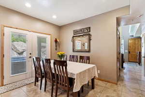 Dining room featuring recessed lighting, light tile patterned floors, and french doors