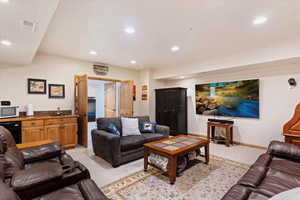 Living area with light carpet, wet bar, and recessed lighting