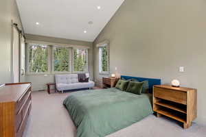 Bedroom featuring carpet, recessed lighting, a barn door, and high vaulted ceiling