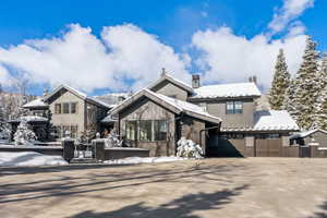 View of front of property featuring brick siding, concrete driveway, a garage, and a patio