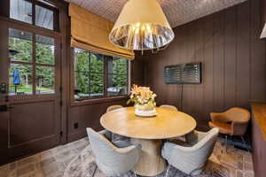Dining area with stone finish floors and wood walls