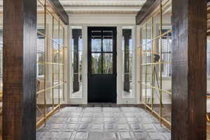 Entryway featuring tile patterned floors, plenty of natural light, and beam ceiling