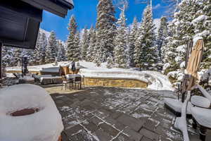 Snow covered patio with a patio area