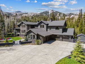 View of front facade featuring concrete driveway, a chimney, a mountain view, a garage, and brick siding