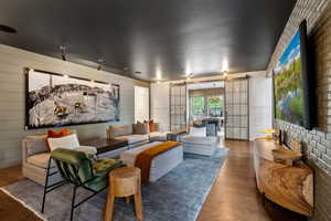 Living room with wood finished floors, a barn door, and wood walls