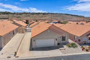 View of front of home featuring a tile roof, a garage, driveway, and stucco siding