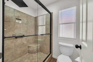 Bathroom with a shower stall and toilet