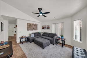 Tiled living room with vaulted ceiling and a ceiling fan