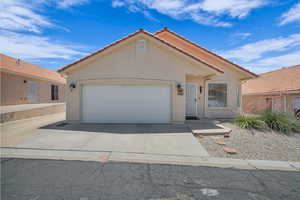 Mediterranean / spanish home with driveway, stucco siding, a tiled roof, and an attached garage
