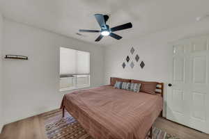Bedroom featuring wood finished floors and a ceiling fan