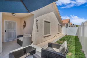 View of patio with outdoor lounge area and a gate