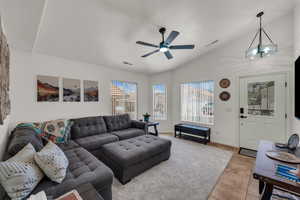 Living area with tile patterned floors, a ceiling fan, a textured ceiling, and high vaulted ceiling