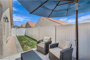Fenced backyard with a patio area and a gate
