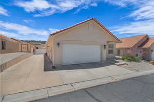 View of front of property with driveway, a garage, stucco siding, and a tile roof
