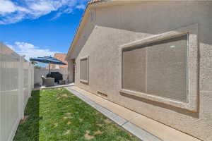 View of side of home with stucco siding and a patio