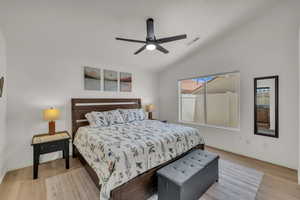 Bedroom with lofted ceiling, light wood-type flooring, and a ceiling fan