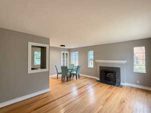 Dining space featuring light wood-style flooring and a tiled fireplace
